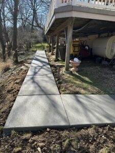 Stamped concrete sidewalk featuring a rustic slate pattern, providing an attractive and long-lasting entrance pathway.