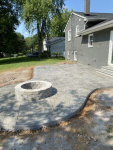 Stamped concrete patio with a textured cobblestone design, ideal for outdoor living spaces like fire pits or lounge areas.