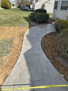 Curved Stamped concrete walkway installation with a modern slate pattern by Morrison Custom Concrete